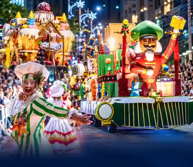 Viva o Natal BC 2026 em Balneário Camboriú Desfile do Viva o Natal BC em Balneário Camboriú, com carros alegóricos iluminados, boneco natalino gigante e artistas fantasiados em uma avenida decorada com luzes de Natal.
